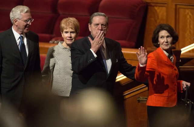 photo d'Elder Holland, membre du collège des 12 apôtres de l'Eglise mormone, quittant le centre de conférence générale aux bras de son épouse et saluant la foule.